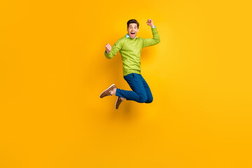 Fototapeta na wymiar Full length body size profile side view of attractive overjoyed cheerful guy jumping rejoicing isolated on bright yellow color background