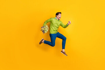 Fototapeta na wymiar Full length body size profile side view of nice cheerful guy jumping running bringing flowers floral isolated on vivid yellow color background