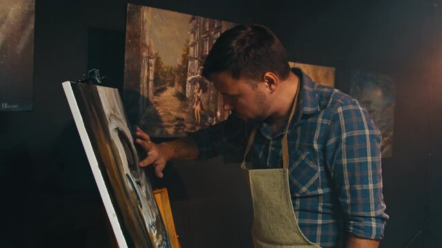 talanted artist using his hands to creat an oil painting picture in art studio.