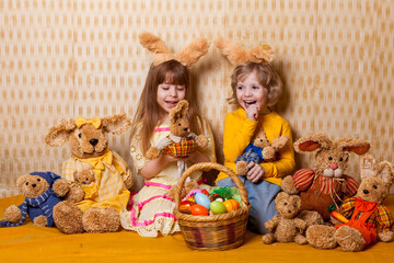 Easter photo of emotional children with a basket of eggs with bunny ears