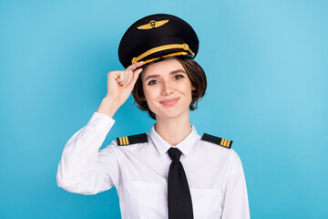 Photo of optimistic nice brunette hair lady wear pilot uniform isolated on blue color background - obrazy, fototapety, plakaty