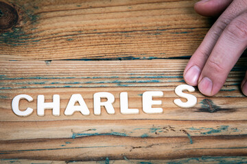 CHARLES. Name of men and boys. Birthday concept. White letters of the alphabet on a wooden...