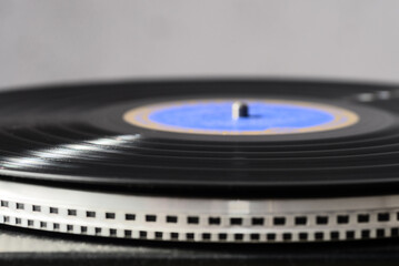 A black vinyl record on a turntable. Selective focus.