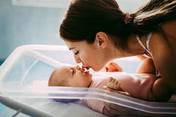 Obraz premium Portrait of beautiful loving mom playing first games with her baby