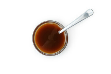 Bowl of caramel sauce with spoon isolated on white background