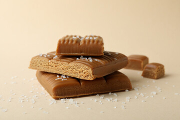 Salted caramel pieces on beige background, close up