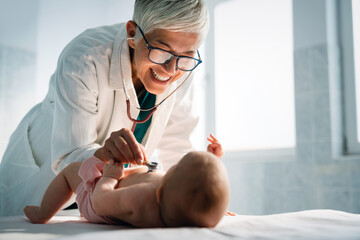 Pediatrician doctor examines baby with stethoscope checking heart beat.