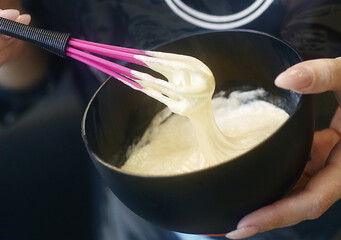 hairdresser hand mixing hair dye for coloring closeup photo