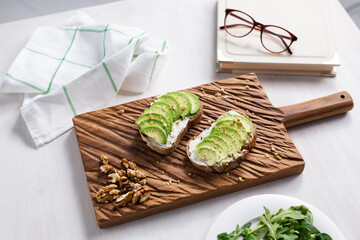 Sliced avocado on toast bread with nuts. Breakfast and healthy food concept.