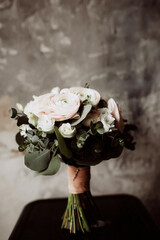 wedding bouquet of white roses and runculus on a gray background