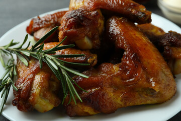 Plate with baked chicken wings, close up