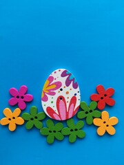 wooden buttons in the form of flowers and eggs on a blue background