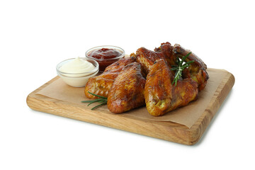 Board with baked chicken wings and sauces isolated on white background