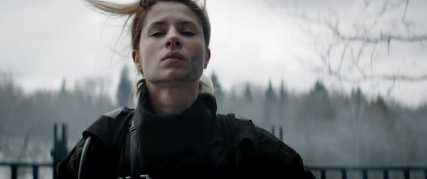 Hero shot, portrait of tired American female firefighter standing outside, looking into camera. Shot with 2x anamorphic lens. 100 FPS slow motion