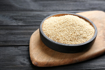 Plate with sesame seeds on black wooden table