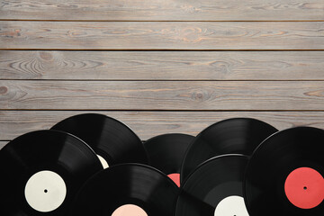 Vintage vinyl records on wooden table, flat lay. Space for text