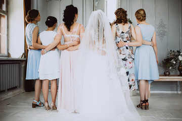 bride with bridesmaids turned back