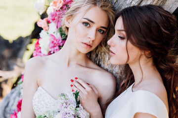 two brides on a background of flowers