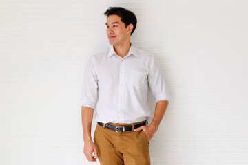 Portrait shot of young adult Asian confident man with cute smiling wearing a formal white long...