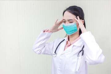 Asian female doctor Sitting in the examination room wearing a mask and pondering in  health care,pollution PM2.5,new normal and coronavirus protection concept.