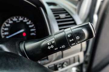 Switch off lights in a car. close-up Car integrated turning indicator with headlight switch toggle.