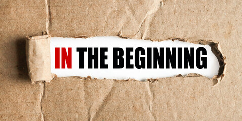 IN The beginning. text on white paper over torn paper background.