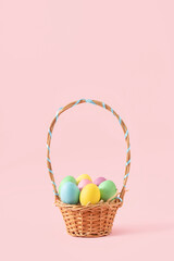 Fototapeta premium Creative concept of an Easter basket full of pastel colored eggs. Minimal Spring decoration on pink background...