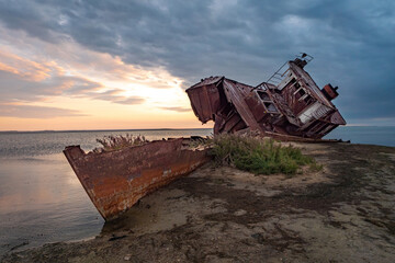 An old abandoned ship on the shore of the drying up Aral Sea. Kazakhstan. Abandoned ships sawn for scrap by local residents. Ecological disaster of the Aral Sea