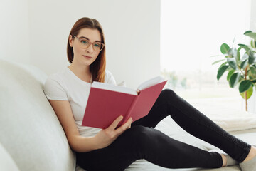 Young woman sitting reading or studying from a large book