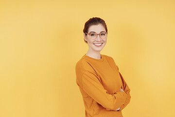 Relaxed sincere smiling young woman with folded arms