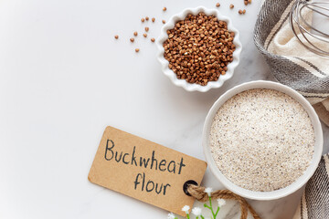 Buckwheat flour and buckwheat seeds with a whisk and a tag. Concept of gluten free cooking and baking