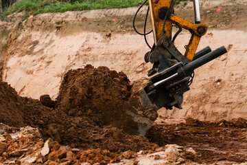 Excavator during construction new road in forest area. Yellow backhoe at groundwork