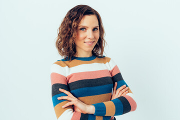 Portrait of confident beautiful young woman with curly brown hair