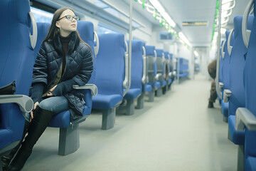 girl sits on a train / winter transport, one adult girl sits by the train window traveling