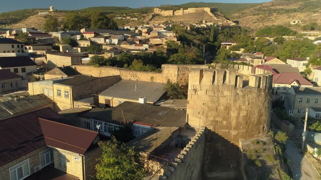 Aerial great stone ancient wall of citadel fortress Derbent Dagestan, military fortification, city landscape. Traditional Caucasus town houses, streets protected from Persians. Russia Caucasus movie