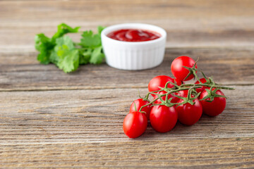 White bowl of tomato sauce with parsley and tomato. Ketchup on natural wooden background
