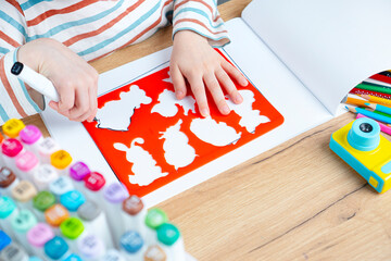 The child draws animals through a stencil. Toddler early preschool education.