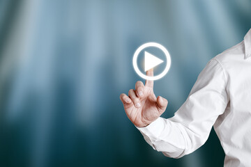 Businessman hand pressing play icon on a virtual display screen.