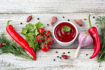 Border of ingredients of tomato sauce. Products for preparing ketchup on white wooden background