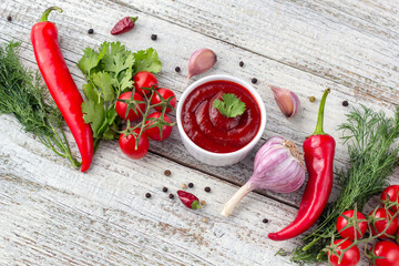 Border of ingredients of tomato sauce. Products for preparing ketchup on white wooden background