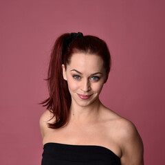 Fototapeta premium close up portrait of red haired women with different facial expressions on a pink studio background.