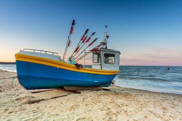 Naklejka na ściany i meble Amazing sunset with fishing boats at the beach of Baltic Sea in Sopot, Poland