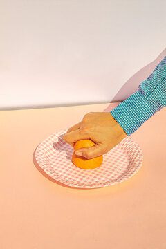 Arm of woman squeezing oranges at vintage kitchen