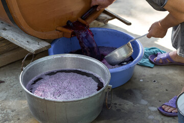 The winemaker pours grape juice for transportation into barrels.