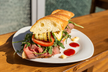 Bar sandwich with roast beef, grilled zucchini, tomato, rocket, ketchup