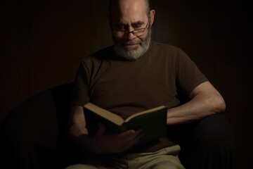 Hombre con fondo oscuro leyendo.