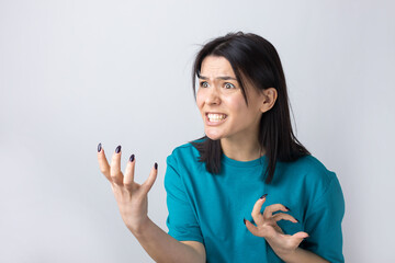 Young beautiful woman with facial expression of surprise standing over gray background.