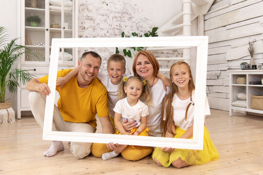 large family holding picture frame