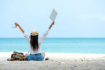 Lifestyle freelance woman using laptop working and relax on the beach.  Asia people success and...