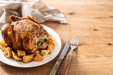 Homemade roasted chicken with potatoes on wooden table.Copy space